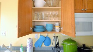 An open kitchen cabinet with dishes, glasses, and utensils. - Cozy Downtown Condo(Dog Friendly) 3.5 Blocks to Beach.1 block to Washington Mall (Cape May)