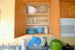 Kitchen equipped with a microwave, sink, and ample storage for kitchenware.