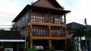 A two-story wooden house with a balcony on the upper floor. - Beau and Blonde House Kamala (Kamala)