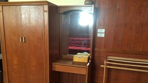 A wooden wardrobe with a mirror and a small desk with a box on it. - Beau and Blonde House Kamala (Kamala)