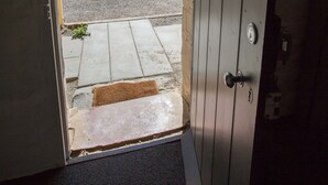 An open door leading to a parking area with a clear view of the surroundings. - Paxton Square Cottages (Burra)