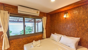 A hotel room with a bed, curtains, an air conditioning unit, and a view of the sea. - Marina Jomtien Beach (Pattaya)