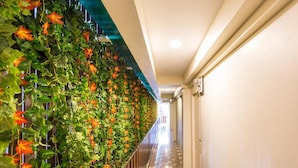 A hallway with a green vertical garden on one side and a tiled floor. - Marina Jomtien Beach (Pattaya)