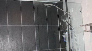 A shower with a glass enclosure, a handheld showerhead, and a handheld faucet. - T Hotel Jalan Tar (Kuala Lumpur)