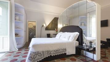 A bedroom with a bed, a bedside table, a mirror, and a wardrobe.