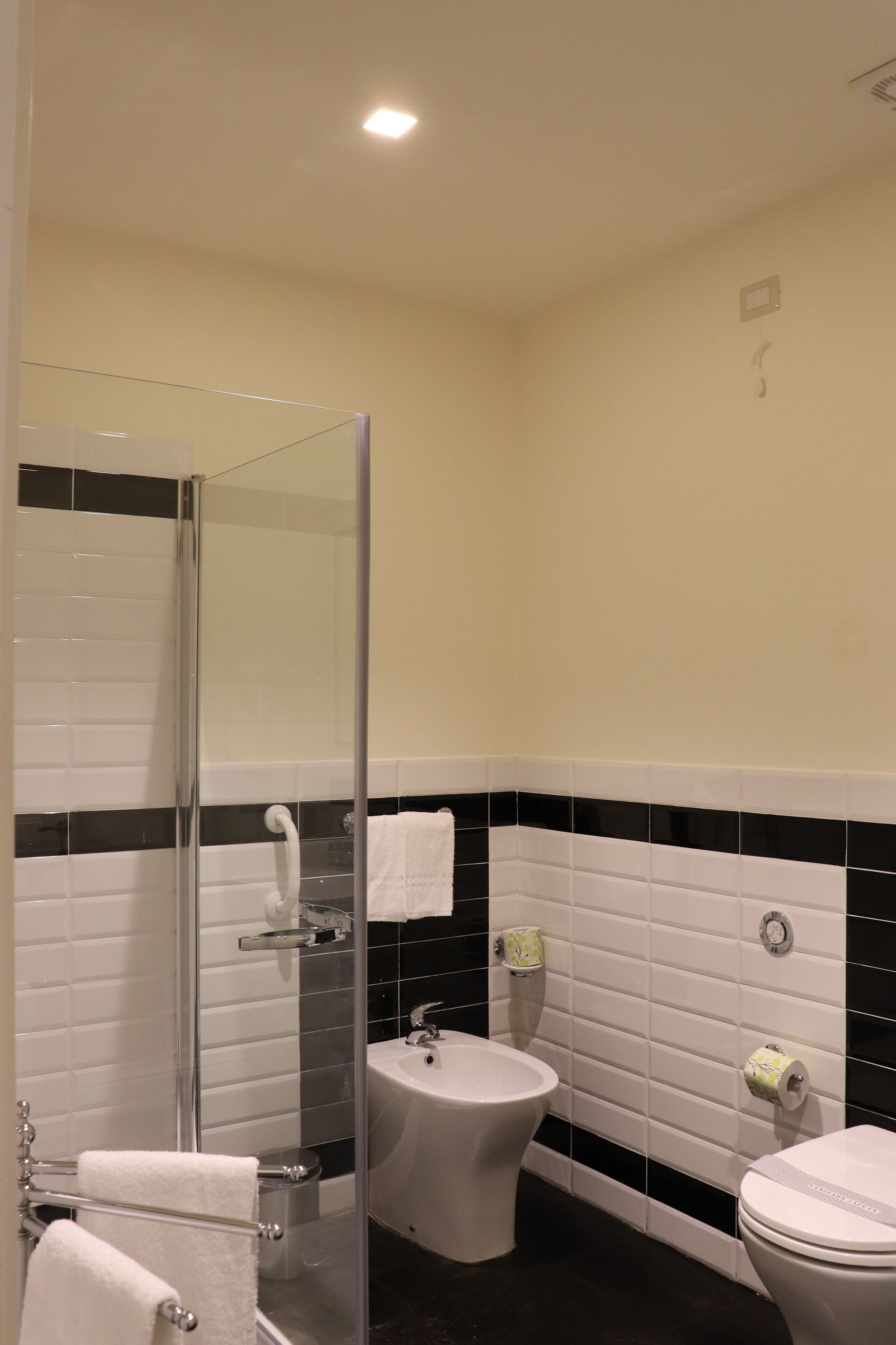 A bathroom with a glass shower enclosure, a sink, and a toilet.