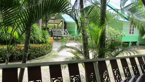 A green building with a porch and a pathway leading to it. - The Green Resort Sri Racha (Si Racha)