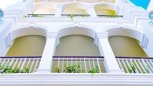 A building with a white facade, balconies with railings, and a sign with Chinese characters. - Shunli Hostel (Phuket)