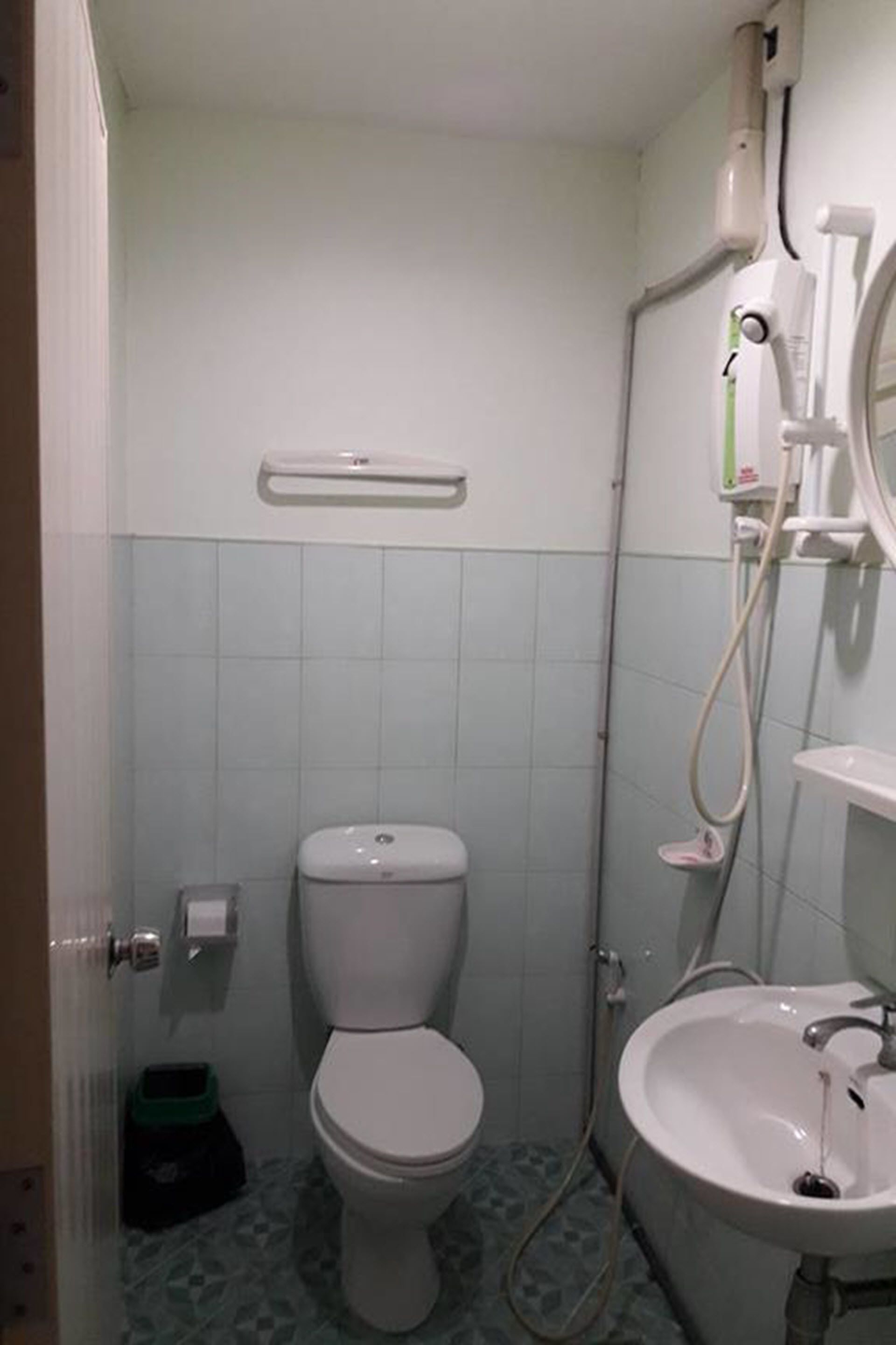 Un baño pequeño con inodoro, lavamanos y ducha.