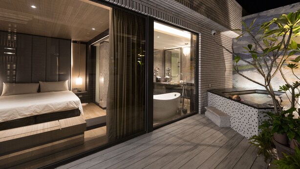 A modern bedroom with a large bed, a glass-enclosed bathroom, and a hot tub outside. - Hotel Valletta (Jiaoxi)
