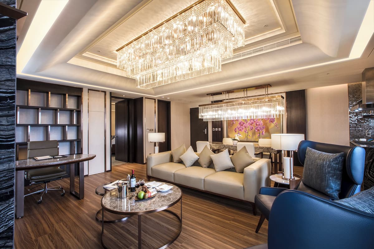 Ein modernes Wohnzimmer mit einer Deckenleuchte, einem Sofa, einem Couchtisch und einem Schreibtisch mit einem Stuhl.