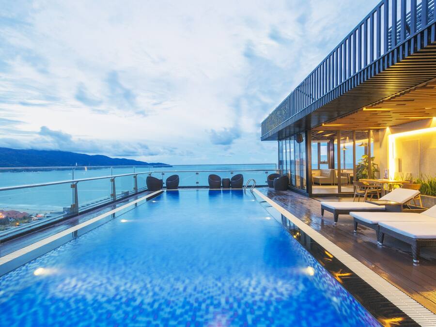 Una piscina al aire libre, sombrillas, sillones reclinables de piscina