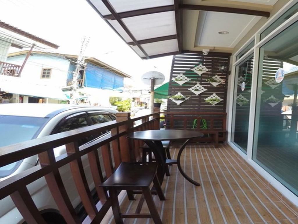 Ein Balkon mit Holzgeländer, einem Tisch und zwei Stühlen.