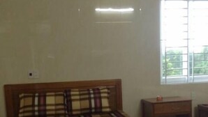 Ein Schlafzimmer mit einem hölzernen Bett, einem Nachttisch und einem Fenster mit Jalousien.