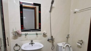 Een badkamer met een wastafel, spiegel, toilet en douche.