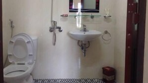 Ein kleines Badezimmer mit Toilette, Waschbecken und Dusche.