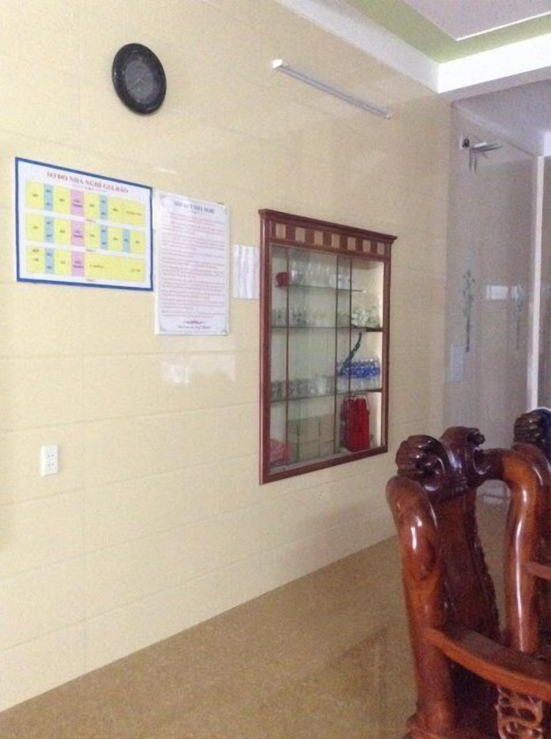 En hall med en anslagstavla, ett vitrinskåp och möbler i trä.
