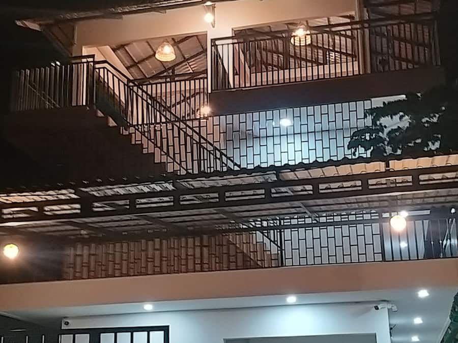 Um edifício de dois andares com escadaria e portão.