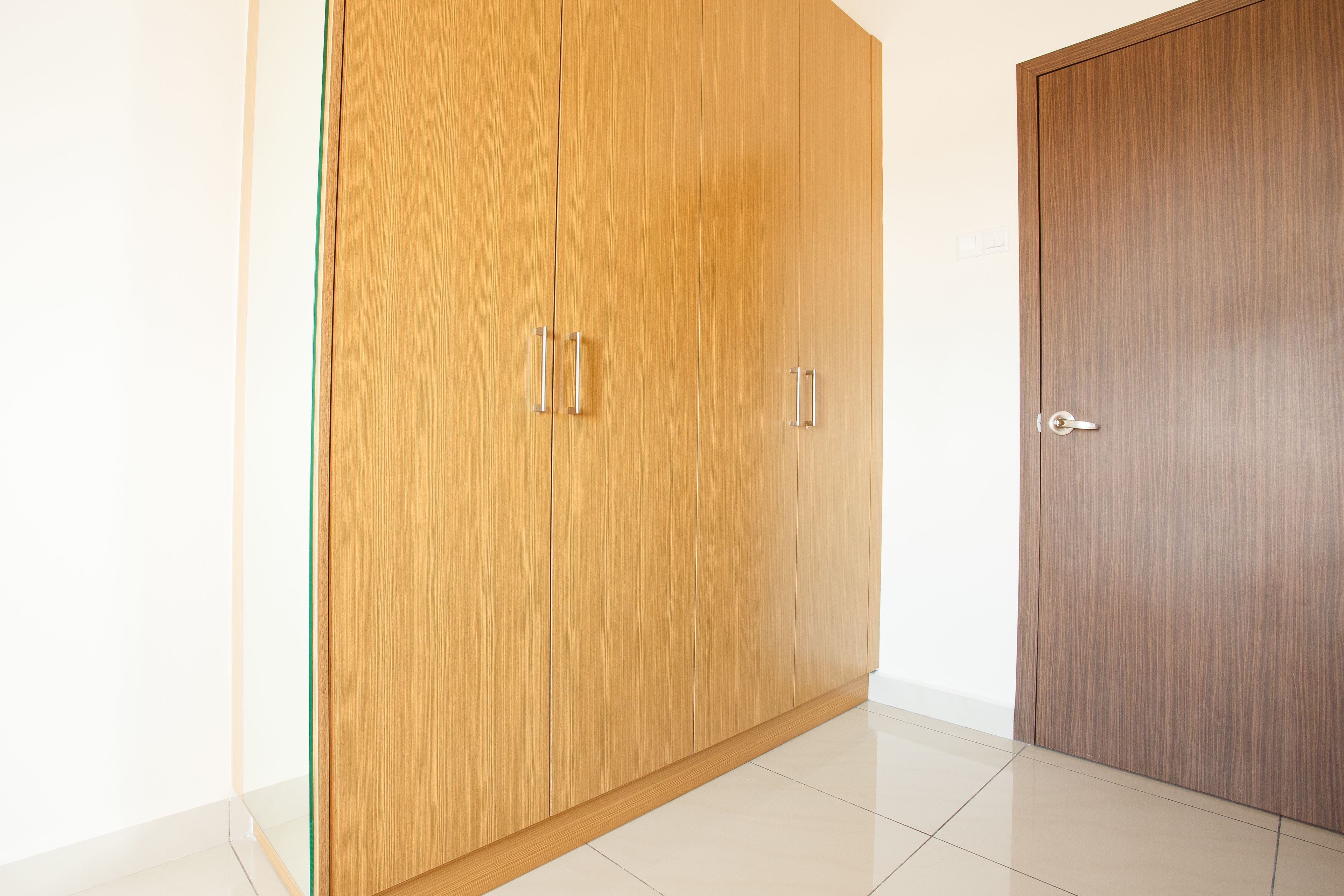 Ein Zimmer mit einem Holzschrank und einer Tür.