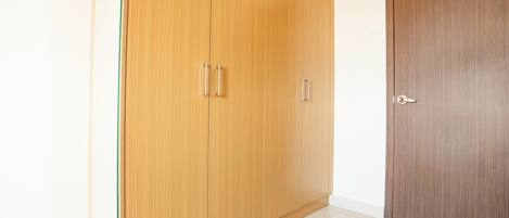 Ein Zimmer mit einem Holzschrank und einer Tür.