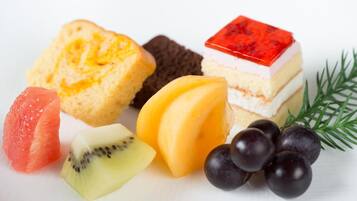 Diversos itens de comida, incluindo doces, frutas e uma sobremesa em camadas.