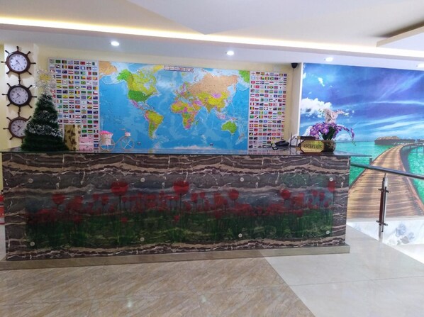 A reception desk with a world map, clocks, and flags.