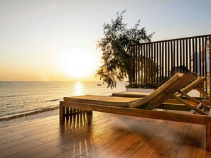 A wooden deck with a lounge chair facing a body of water at sunset. - Nungwi Dreams by Mantis (Nungwi)