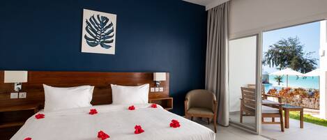 Hotelkamer met een groot bed, een houten hoofdeinde, uitzicht op de omgeving, een stoel en een tafel.