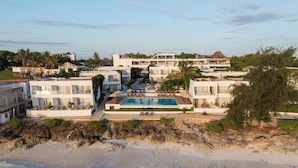 Un resort con piscina, acceso directo a la playa y varias edificaciones.