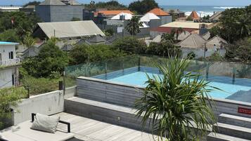 Een buitenzwembad, ligstoelen bij het zwembad