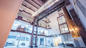 A multi-level atrium with a glass bridge connecting floors, a central open space, and a ground-level entrance. - Vinh Hoang Hotel (Dong Hoi)