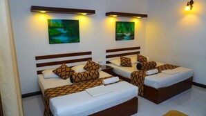 Habitación de hotel con dos camas, cada una con ropa de cama estampada y cabeceros.