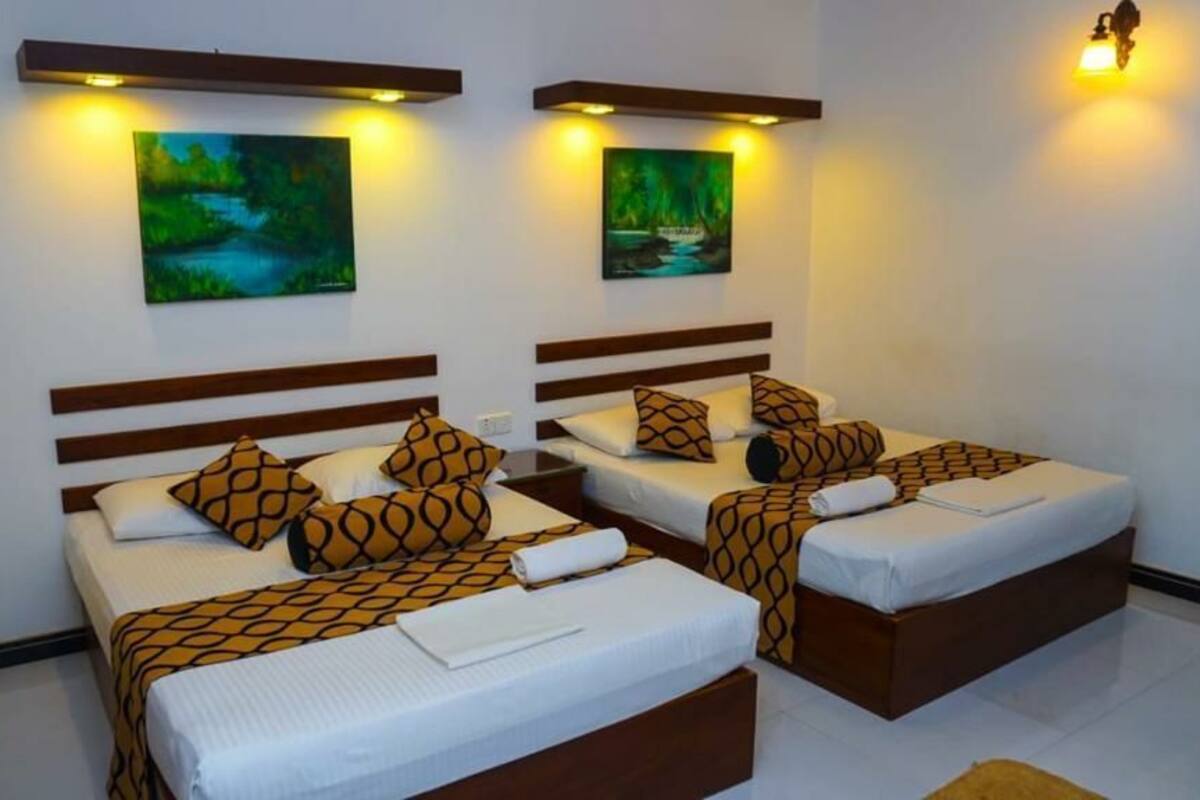 Een hotelkamer met twee bedden, elk met beddengoed met een patroon en hoofdeinden.