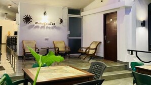 Un interior moderno con una zona de estar que incluye una mesa y sillas, una escalera y una pared decorada con motivos de luna y sol.