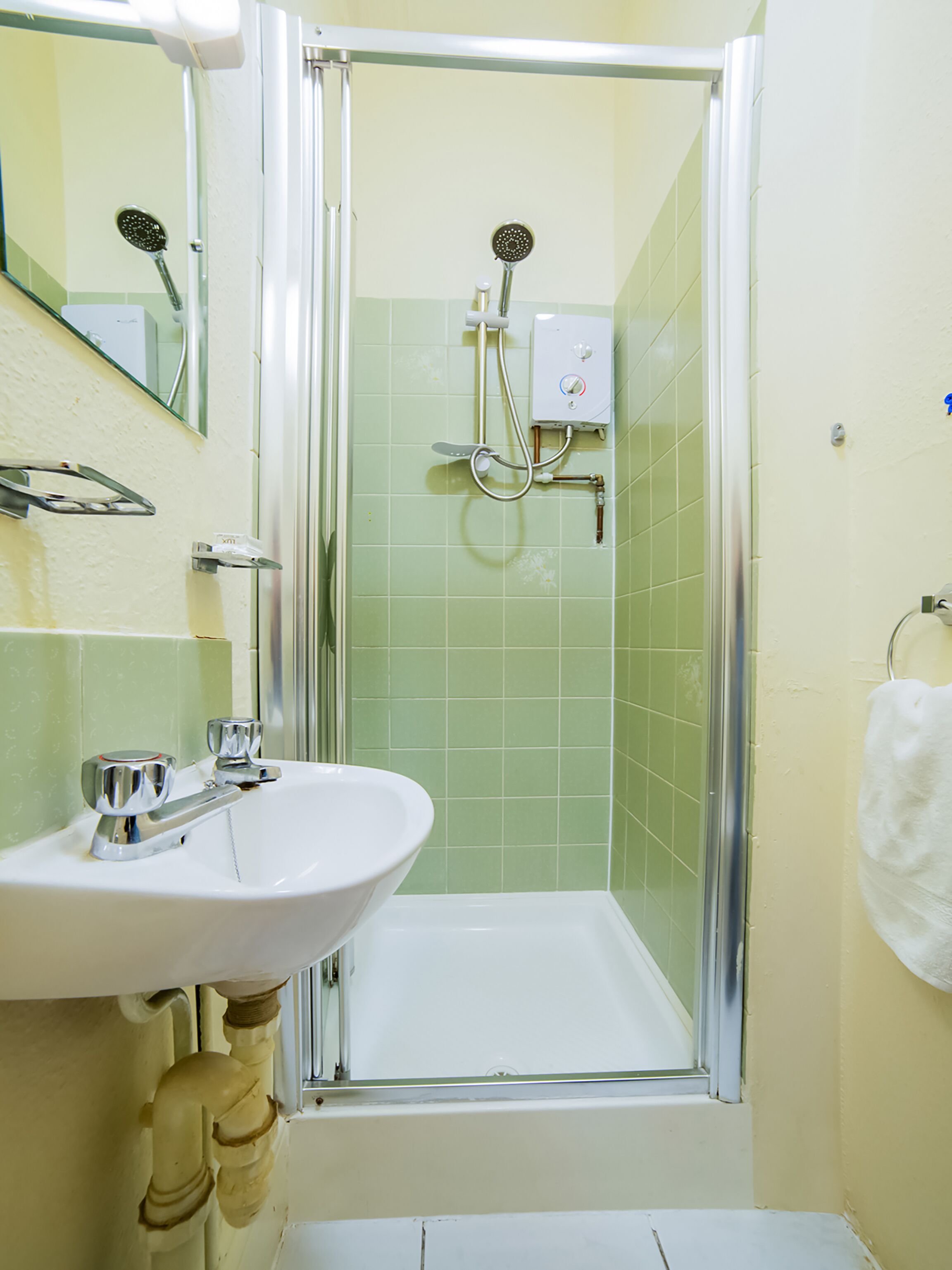 Ein Badezimmer mit Dusche, Waschbecken und Spiegel.