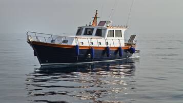 Ein Boot mit einer Kabine, Rettungsringen und einer Angel.