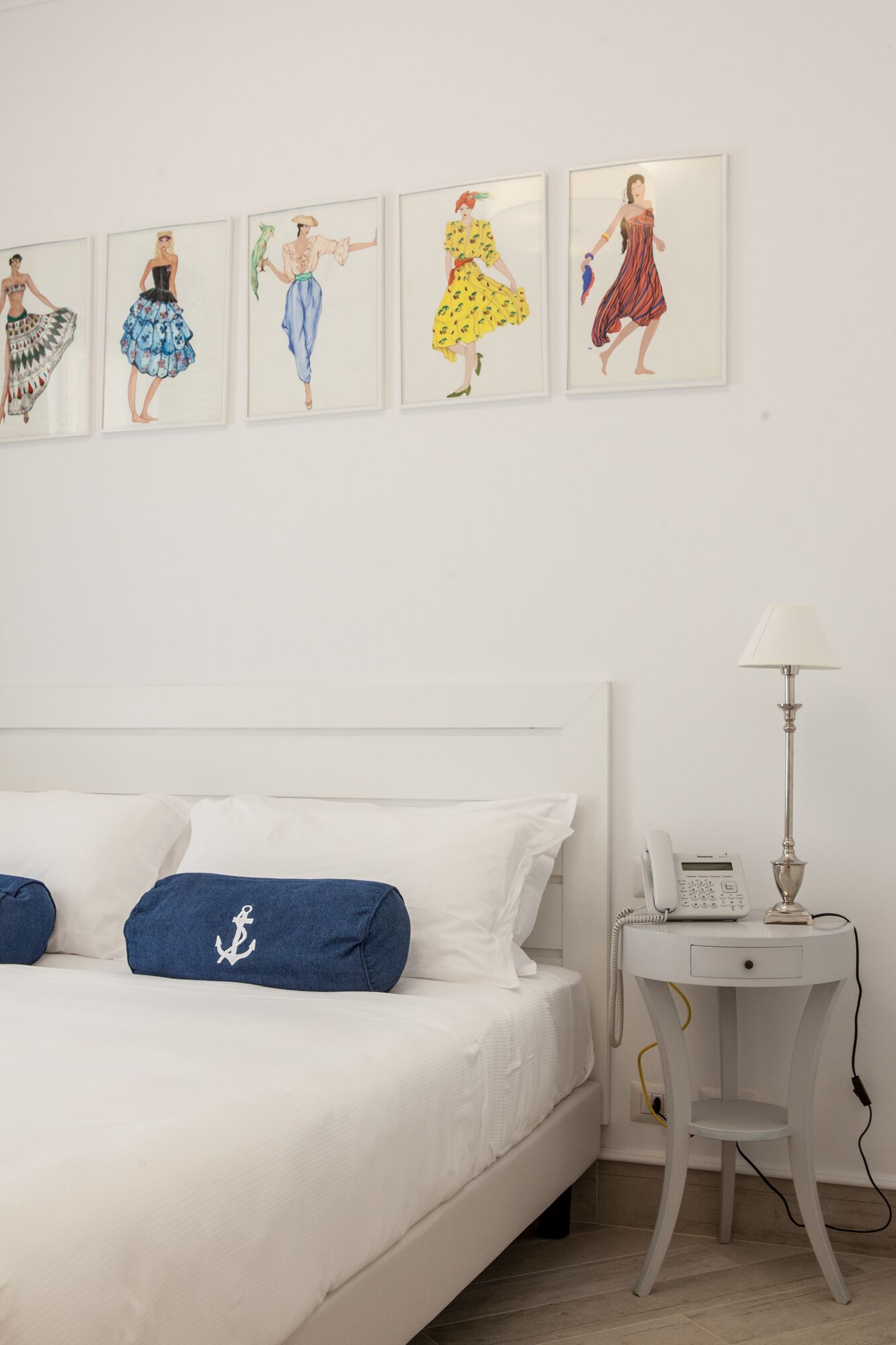 A bedroom with a bed, pillows, a bedside table with a lamp, and a phone.