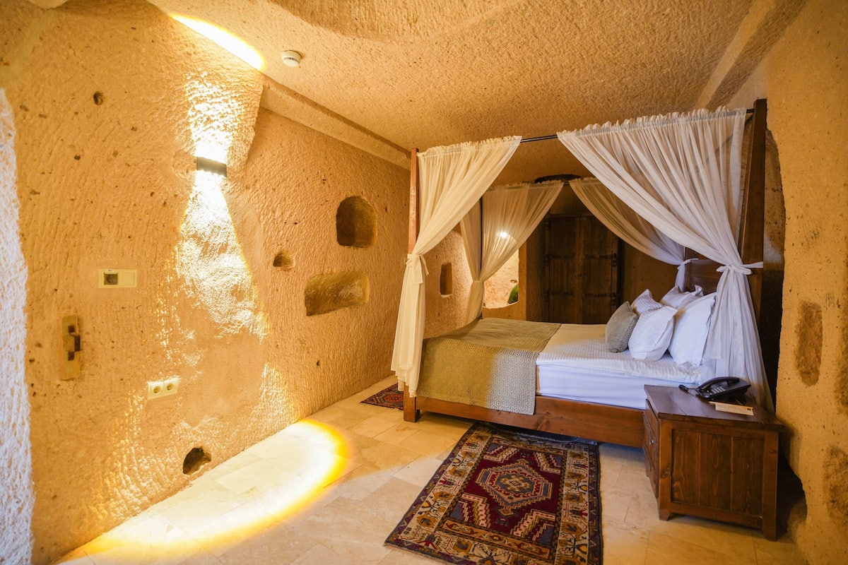 A room with a bed, a nightstand, a patterned rug, and a unique textured wall.