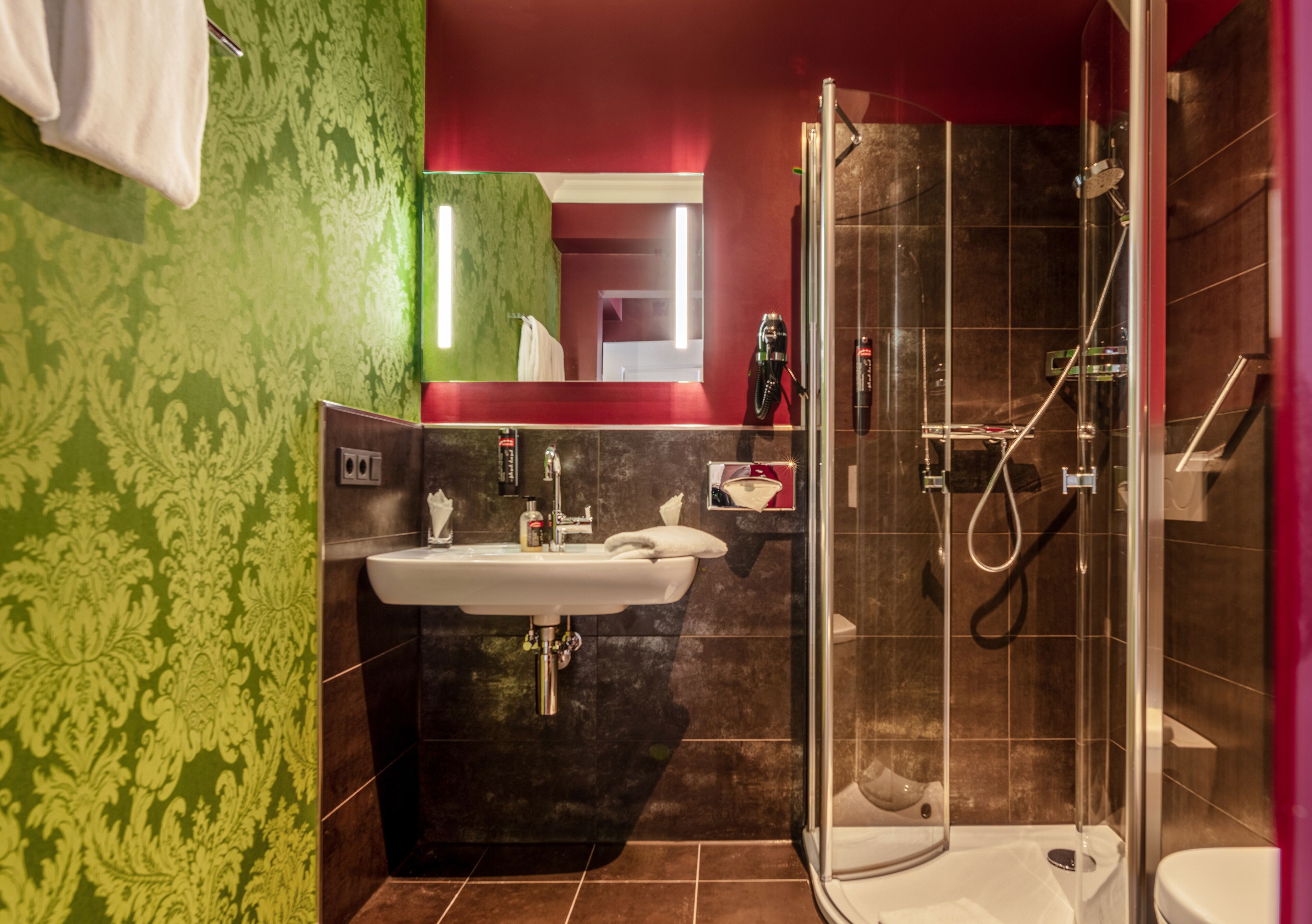 Ein modernes Badezimmer mit einer Duschkabine, einem Waschbecken und einem Spiegel.