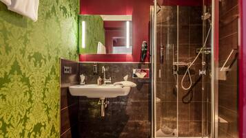 Ein modernes Badezimmer mit einer Duschkabine, einem Waschbecken und einem Spiegel.