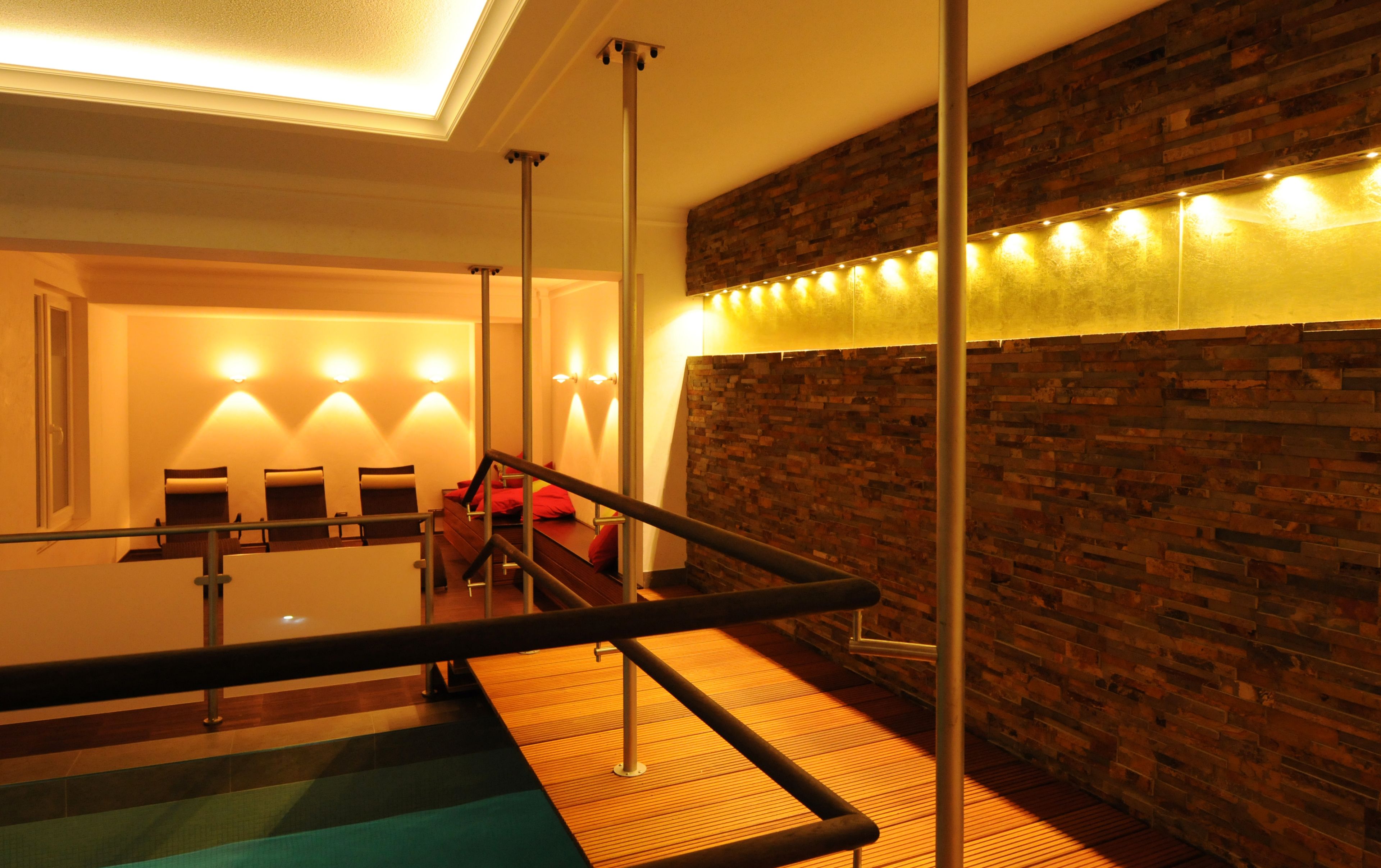 A spa area with a wooden wall, a pool, and seating.