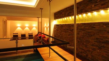 A spa area with a wooden wall, a pool, and seating.