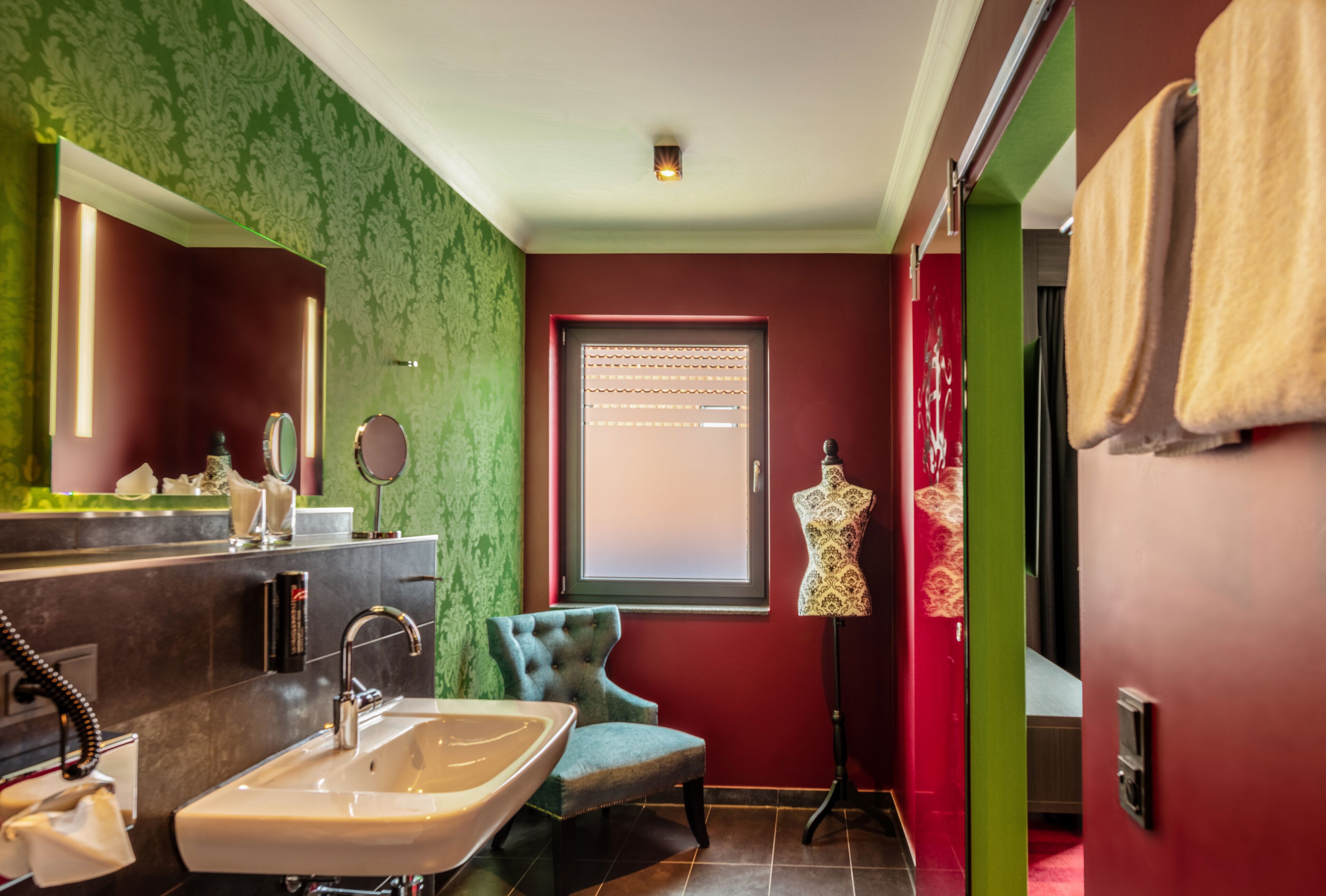 A bathroom with a vanity, sink, mirror, and a mannequin.