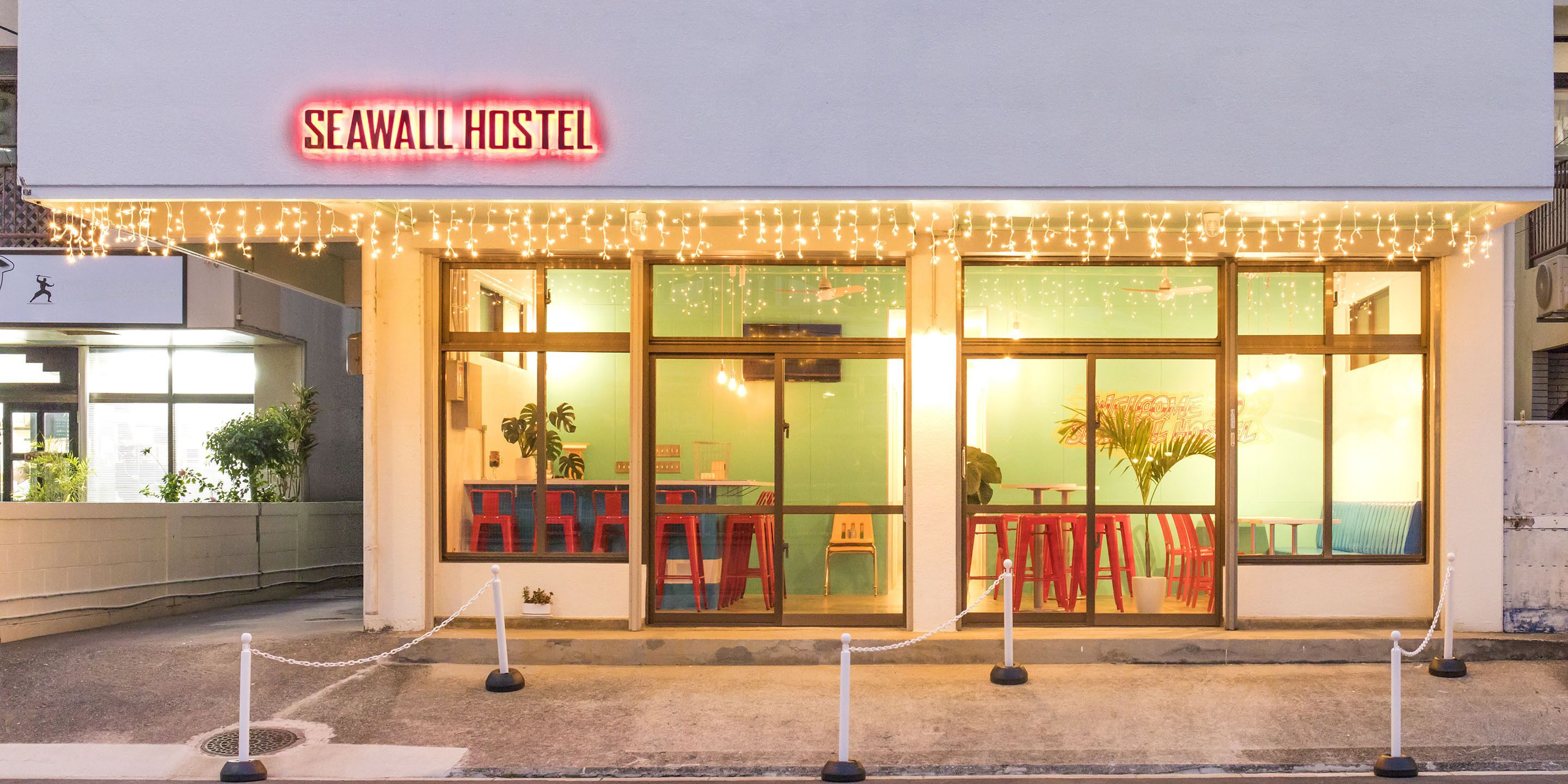 The exterior of Seawall Hostel with a chain barrier in front.