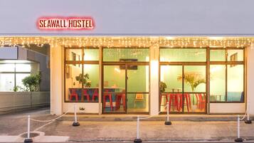 The exterior of Seawall Hostel with a chain barrier in front.