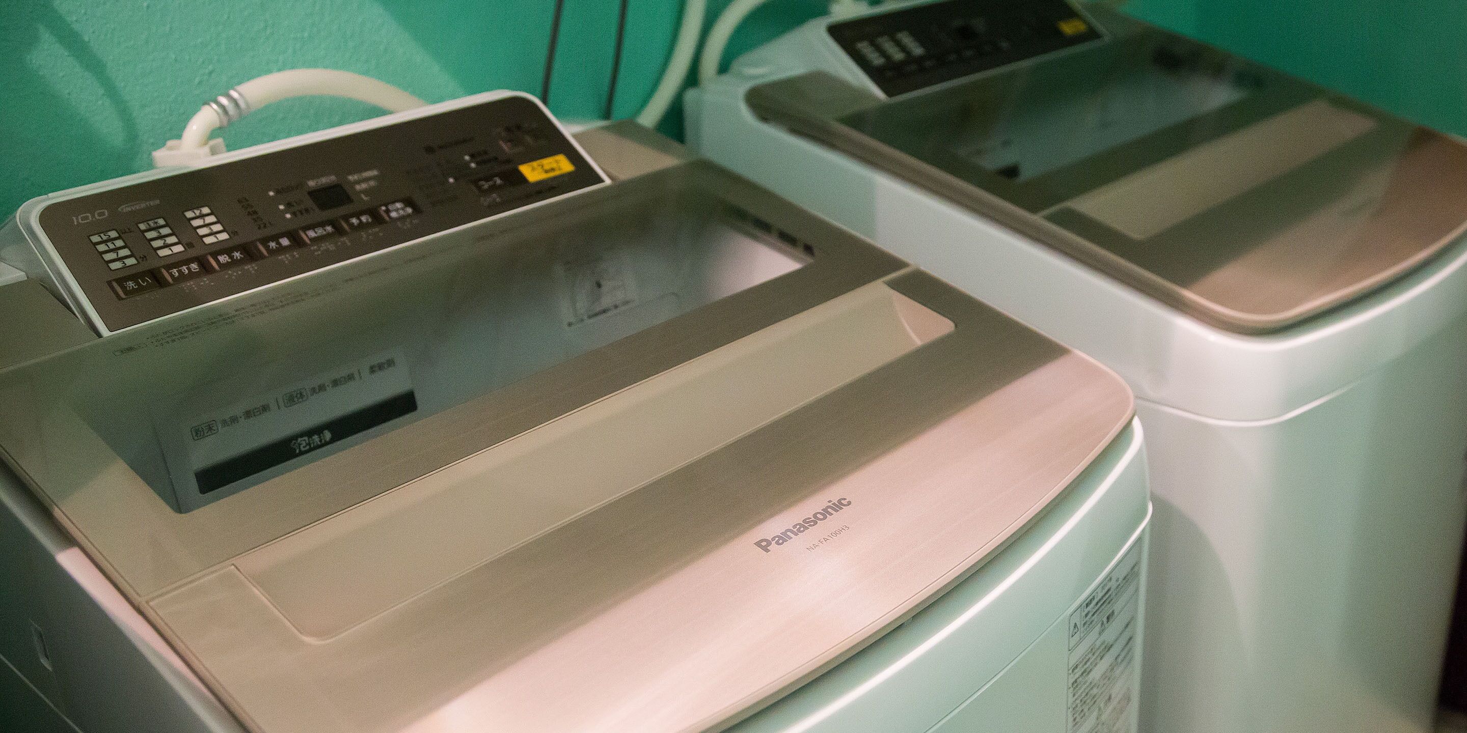Two washing machines with control panels, one with a digital display and the other with buttons.