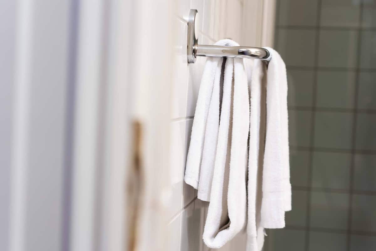 A bathroom with a towel rack holding a white towel.