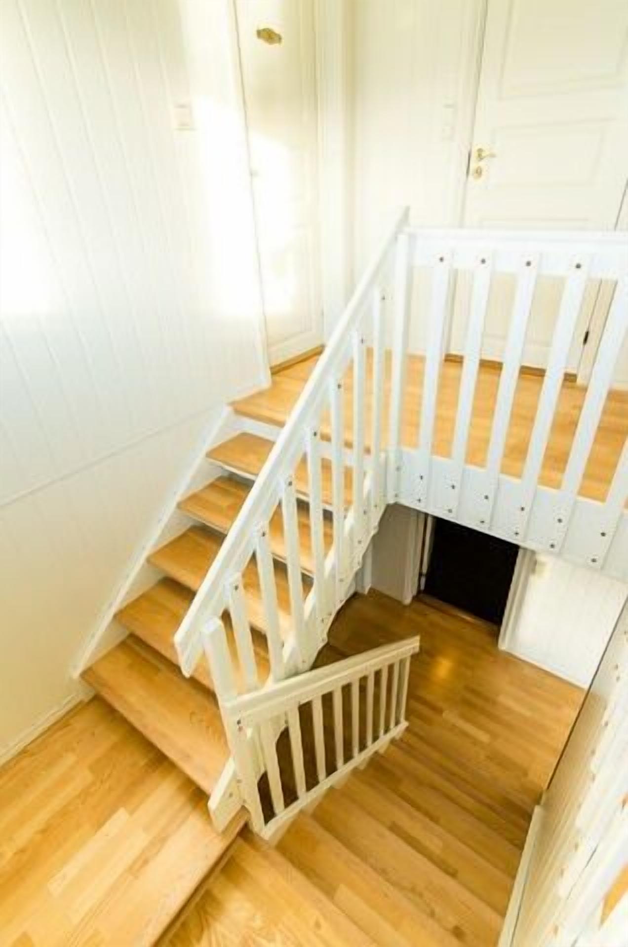A staircase with white railings and wooden steps.