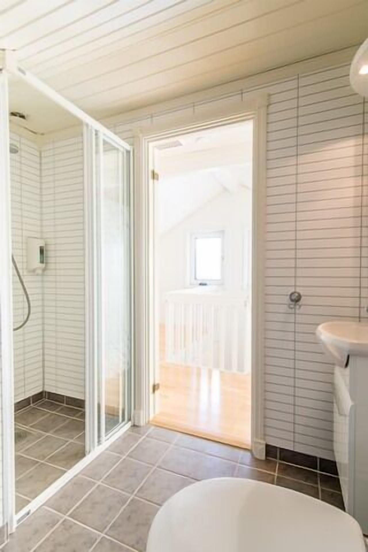 Un baño con ducha, inodoro y lavabo.