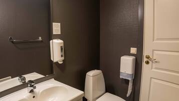 Un baño con un lavamanos blanco, un inodoro y una puerta.